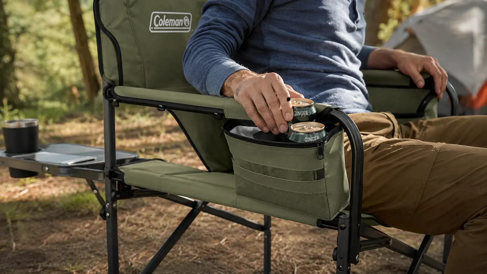 Close-up of built-in cooler pocket on a camping chair armrest holding two cans