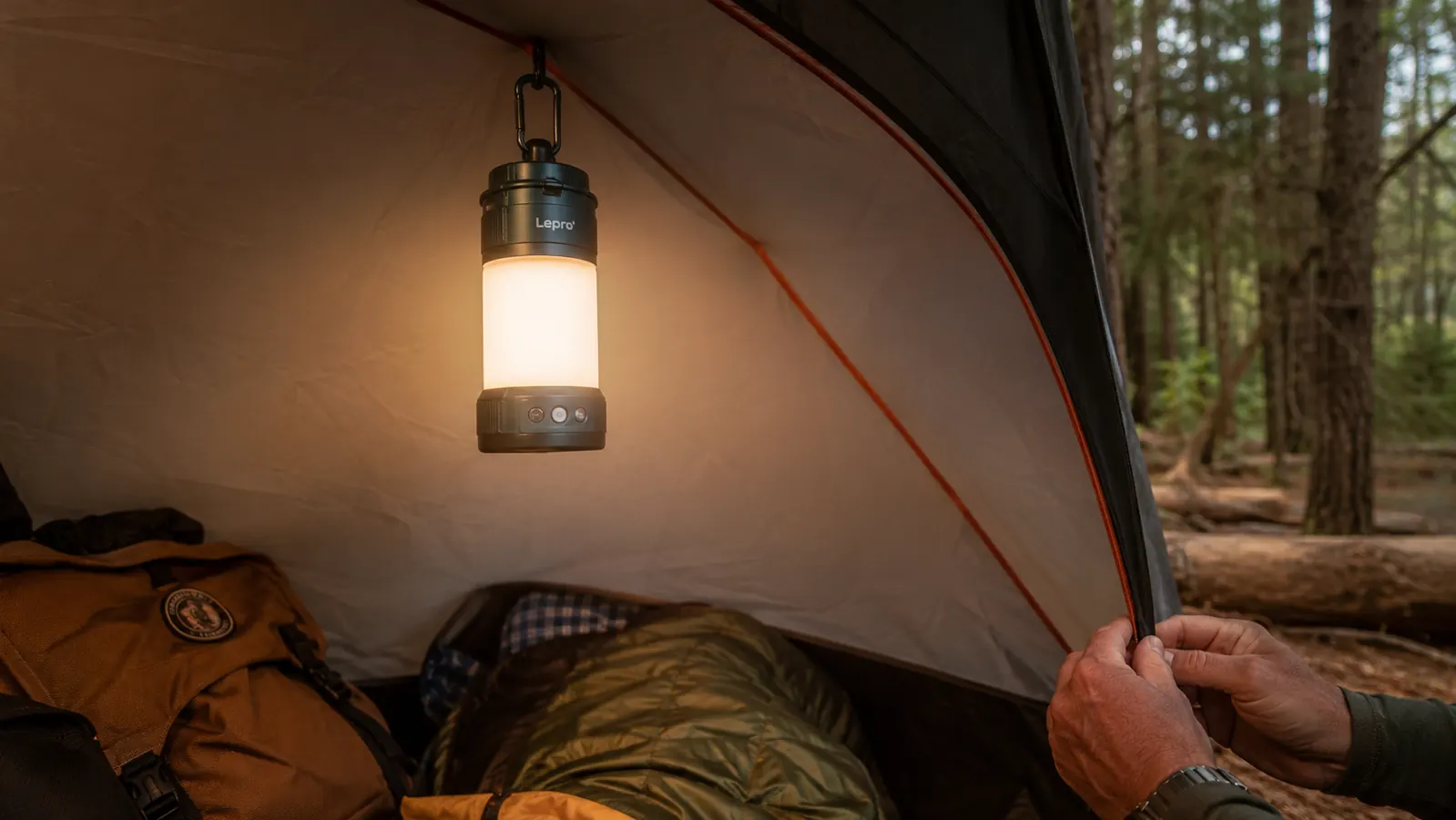 Lepro rechargeable camping lantern hanging from a tent loop inside a canvas tent, illuminating the interior with warm white light